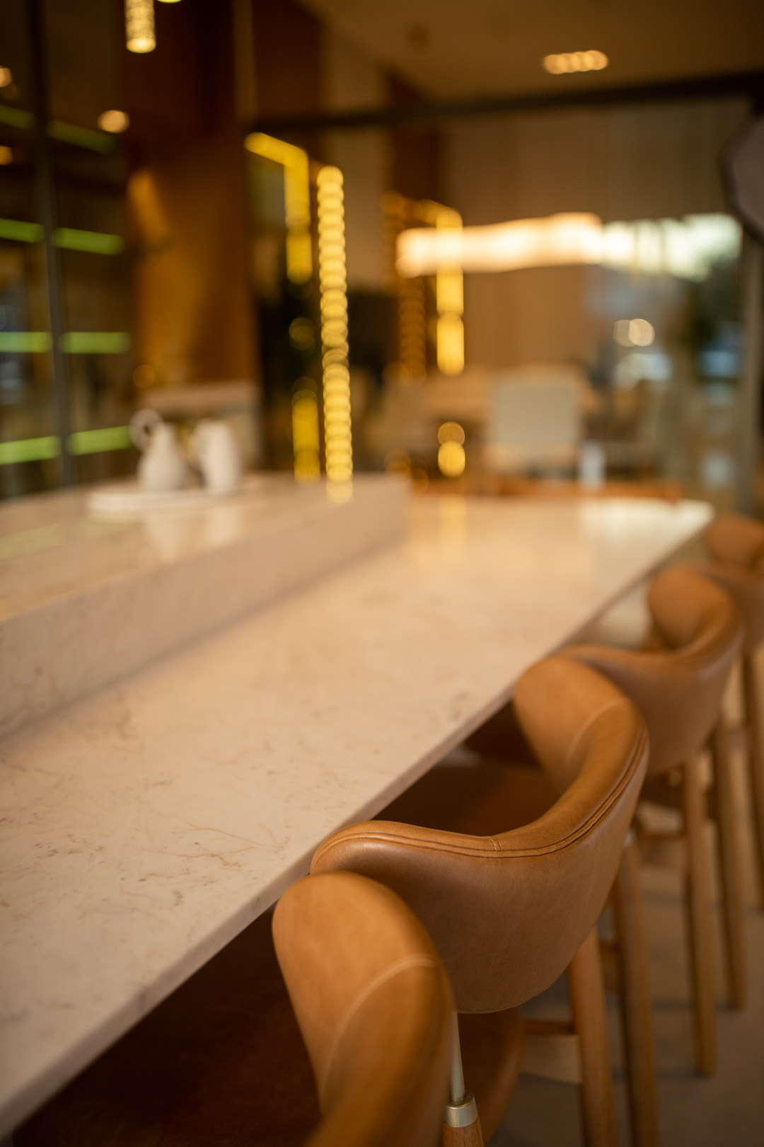 Ilha em mármore com banquetas em couro